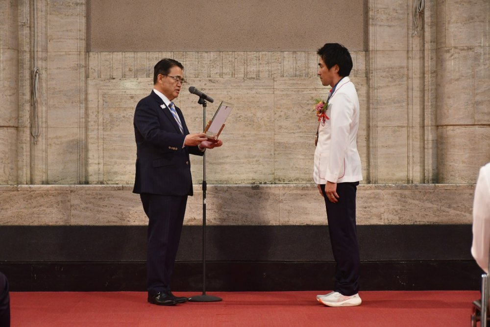 受賞者に表彰盾を授与する大村知事